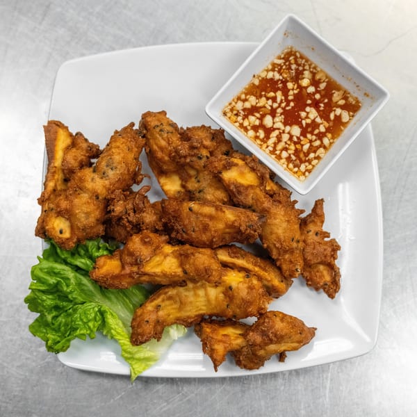 Crispy fried banana fritters with black sesame seeds, served with lettuce and a sweet chili dipping sauce.