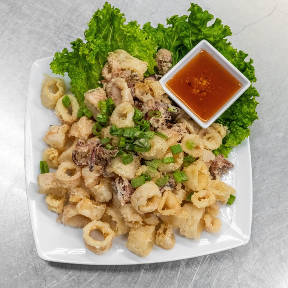 Crispy fried calamari rings and tentacles, garnished with green onions and served with a sweet chili dipping sauce.