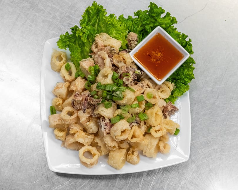 Crispy fried calamari rings and tentacles, garnished with green onions and served with a sweet chili dipping sauce.